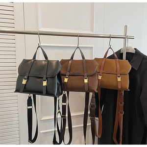 Three colors of retro leather handbags hanging with adjustable straps and gold buckles