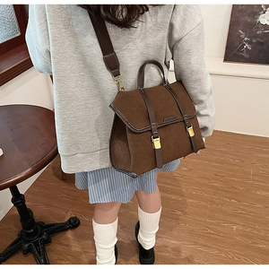 Nahaufnahme der braunen Retro-Tasche aus Mattleder mit Metallschnalle und Gurt