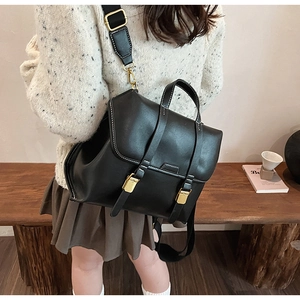 Detailansicht des schwarzen matten Lederrucksacks mit weißen Nähten und Metallschnallen