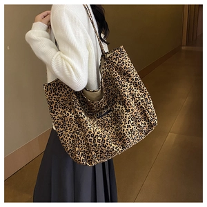 Close-up of leopard print canvas tote bag showing soft texture and large capacity on model