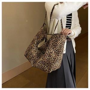 Chic leopard print canvas tote bag shown on shoulder in a stylish indoor setting