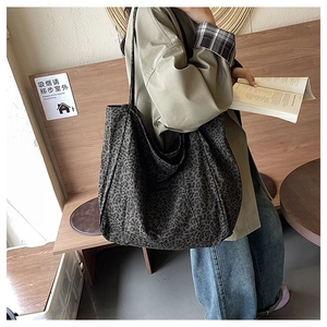Close-up of a large leopard print tote bag in soft canvas fabric with long shoulder straps