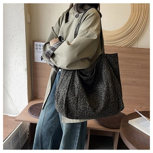 Detailed side view of large leopard print tote bag worn on shoulder for daily commute