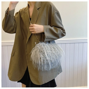Close-up of light grey faux fur crossbody bag featuring a gold beaded chain strap