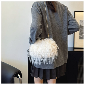 Detailed view of white faux fur shoulder bag featuring elegant gold beaded chain strap