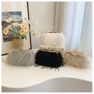 Macro detail of plush faux fur clutch bags in white and grey with gold metal clasps