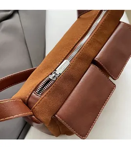 Detailed close-up of smooth silver zipper and side pockets on retro brown shoulder bag