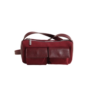 Detail of burgundy faux suede baguette bag showing dual pockets and smooth leather texture