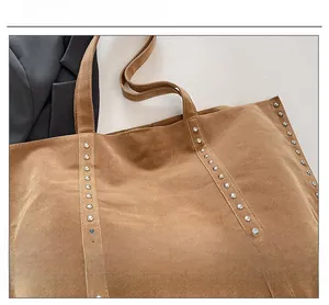 Détail du grand sac cabas en daim marron avec rivets vintage sur cuir texturé