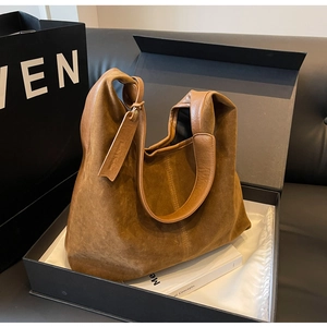 Detail of vintage brown suede hobo bag featuring 'Smile & Fashion' leather hangtag and handle