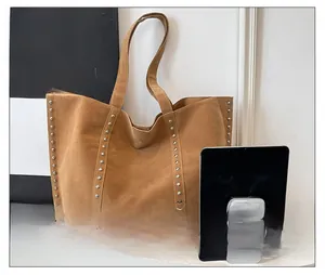 Grand sac cabas en daim marron avec rivets, vue détaillée de la taille avec une tablette