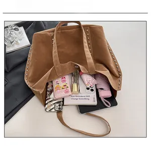 Détail montrant la grande capacité intérieure de ce sac cabas en daim à rivets