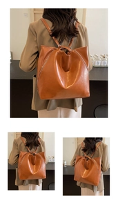 Rear view of brown leather bucket backpack with white stitching details on a model