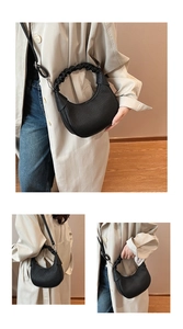 Detail of black crescent bag with ruched handle and fine pleated texture on faux leather