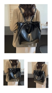 Detail of black faux leather tote with white stitching and silver side zipper accents