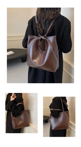 Detail of dark brown leather tote bag with white stitching and convertible straps