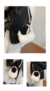 Detail of white crescent bag with vertical pleated texture and cloud-like handle