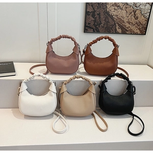 Detail shot of pleated dumpling bags in five colors with textured handles and straps