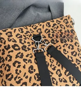 Detail of silver metal lobster clasp and D-ring on a leopard print shoulder bag