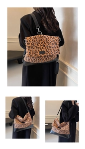 Detail of vintage leopard print crossbody bag with black leather stitching and silver hardware