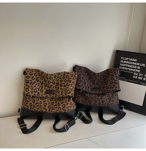 Detail of leopard print canvas backpacks in tan and dark brown with leather trim
