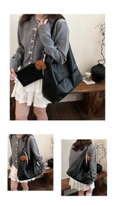 Detail of black leather tote bag with teddy charm, silk scarf, and inner pouch