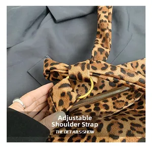 Detail view of leopard print canvas bag featuring a golden metal ring and zipper closure
