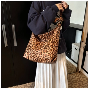 Fashionable leopard print tote bag with wide shoulder strap shown on a model
