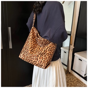 Detail of a large leopard print tote bag with brown and black patterns worn over the shoulder