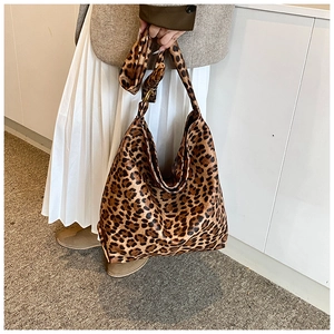 Detail of leopard print canvas hobo bag with wide shoulder strap and matching ribbon tie