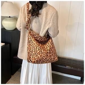 Detail of knot shoulder strap and leopard print texture on a large hobo bucket bag