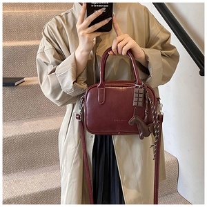 Retro Boston Handtasche für Damen, stilvolle Umhängetasche mit süßen Anhängern in Dunkelrot.