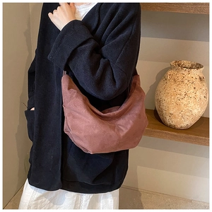 Détail d'un sac hobo chic en daim synthétique avec une texture douce rouge brique