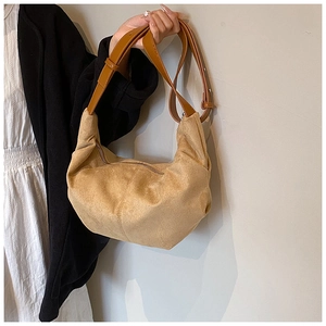 Détail du sac bandoulière en suédine terreuse avec design plissé en demi-lune et lanière en cuir