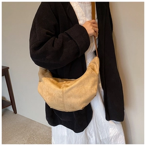 Sac bandoulière en daim kaki en forme de demi-lune, présenté de profil sur un mannequin