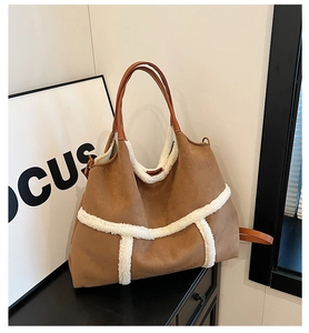 Détail du sac cabas en suède avec bordure en peau lainée blanche et anses en cuir marron rétro