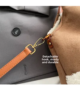 Detail of sturdy gold alloy detachable strap hooks on brown suede tote with faux fur trim