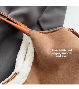 Detailed macro view of handmade white stitching on brown matte suede tote bag