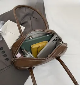 Macro shot of brown leather shoulder bag interior showing ample storage for daily essentials