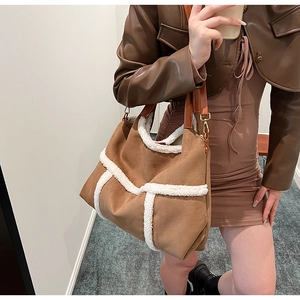 Detail of suede tote bag with brown leather handles and plush white faux fur trim