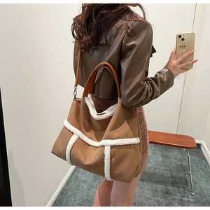 Brown suede tote bag featuring plush white faux shearling trim and leather handles