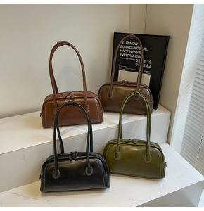 Four retro leather Boston bags in black, olive, brown, and dark coffee on display stands