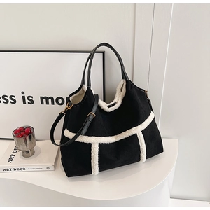 Detail of black suede tote bag with white fleece trim on an artistic minimalist display