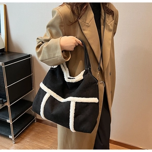 Black suede tote bag with white shearling trim and detachable strap on model