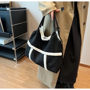 Detail of a black matte tote bag featuring stylish white faux fur trim and leather straps