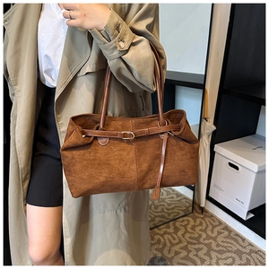 Detail of dark brown frosted suede tote bag with leather strap and metal buckle