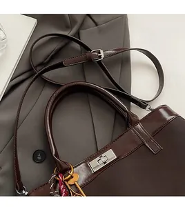 Close-up of brown wax leather tote bag with silver turn lock and adjustable shoulder strap