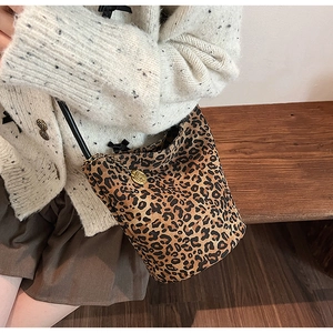 Detail of vintage leopard print bucket bag with gold pendant and black strap