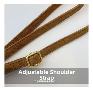 Détail de la bandoulière réglable en daim marron avec boucle en métal doré poli