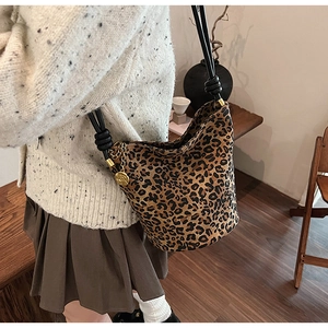 Close-up of leopard print bucket bag with black knotted strap and gold rose charm